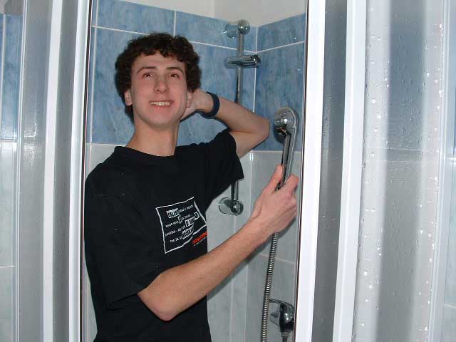 Vojta se sprchuje až značně oblečen.