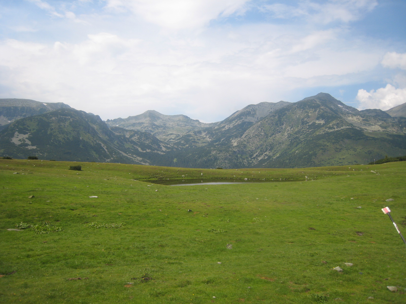 Sedlo Saua Plaiul Mic 1 879 m.n.m. s výhledem na Vf. Peleaga (vpravo) a Vf. Retezat (uprostřed). Poté následoval sestup asi 300 m dolů do chaty Buta.